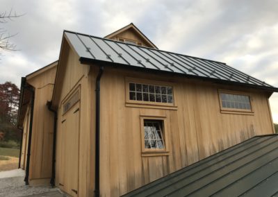 Black downspouts. Beautiful barn doors perfectly aligned. Snow guards on the standing seam metal roof.
