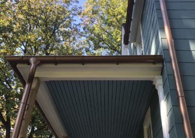 Copper gutter system on porch and from second floor. Long downspout coming down the outside wall. Beautiful looking system.