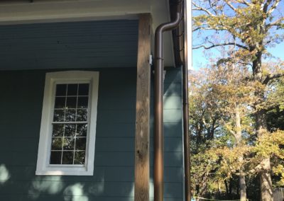 Copper metallic gutters and downspouts. Looking more bronze in the shade. Very appealing color.