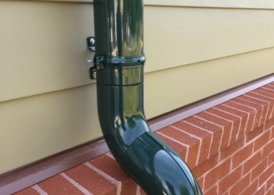 Elbows going over a water table in red brick. The system is painted in a special green color.